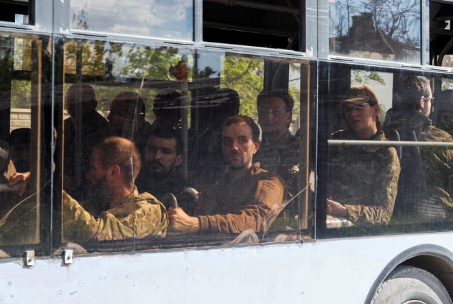 Avtobus s pripadniki ukrajinskih oboroženih sil, ki so se predali v poraženi jeklarni Azovstal, v spremstvu proruske vojske v Mariupolju. FOTO: Alexander Ermochenko/Reuters
