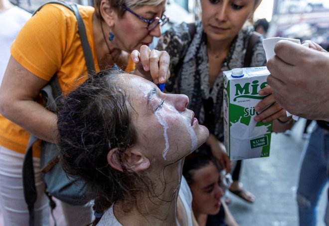 Ljudje vlivajo mleko v oči protestnici, ki jo je prizadel solzivec. Protestniki se spopadajo s policijo ob 9. obletnici protestov v parku Gezi v Istanbulu, ko je leta 2013 po Turčiji več stotisoč ljudi protestiralo proti načrtom za gradnjo replike osmanske vojašnice v mestnem parku Gezi. Vse skupaj je preraslo v vsesplošne proteste proti vladi predsednika Erdogana. Foto: Umit Bektas/Reuters
