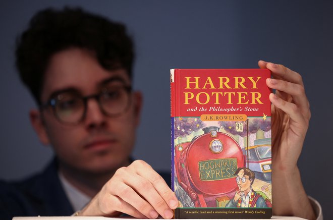 Mark Wiltshire z enim od redkih kopij prve knjihe o mladem čarodeju Harryju Potterju. FOTO: Henry Nicholls/Reuters
