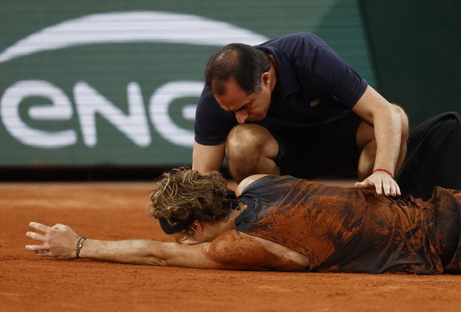 Alexander Zverev se je zgrudil v bolečinah. FOTO: Yves Herman/ Reuters
