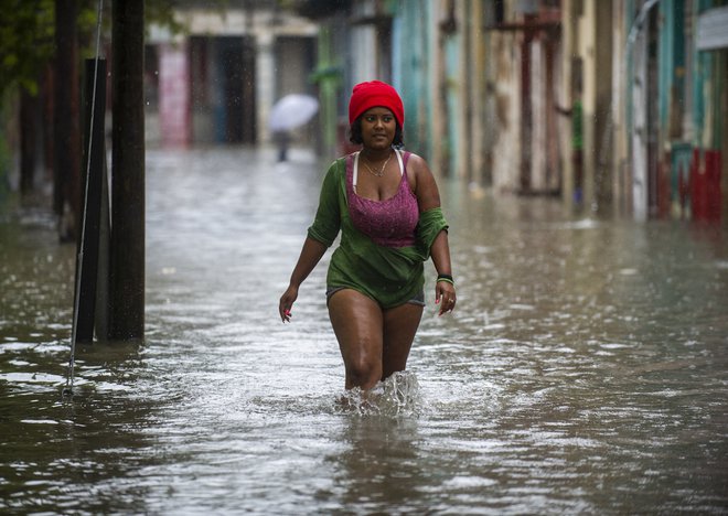 Ženska se prebija po poplavljeni ulici v Havani. - Ostanek orkana Agatha je v zahodnih in osrednjih provincah Kube povzročl intenzivno in vztrajno deževje. Foto: Yamil Lage/Afp

