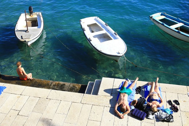 Če je po eni strani v sodobni družbi izrazito razširjen strah pred staranjem (kože), se med sprehodom po plaži še vedno lahko čudimo nekaterim, ki se namerno izpostavljajo soncu. FOTO: Tomi Lombar/Delo
