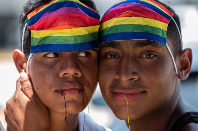 Venezuelska migranta Joel Garcia (24) in Yeisson Matamoros (22), člana skupnosti LGBT, ki sta del karavane, namenjene v ZDA, protestirata z zašitimi usti pri Nacionalnem inštitutu za migracije (INM) v Huixtli in zahtevata humanitarne vizume. Na tisoče migrantov je v sredo začelo prejemati začasne mehiške vizume, saj se pripravljajo na nadaljevanje poti proti ZDA. Migranti so postavili začasni tabor na košarkarskem igrišču v mehiškem mestu Huixtla. Foto: Pedro Pardo/Afp
