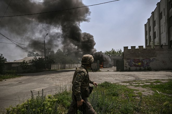 Ukrajinski vojak v mestu Lisičansk na vzhodu Ukrajine, kjer potekajo srditi spodati med ukrajinsko in rusko vojsko. FOTO: Aris Messinis/Afp
