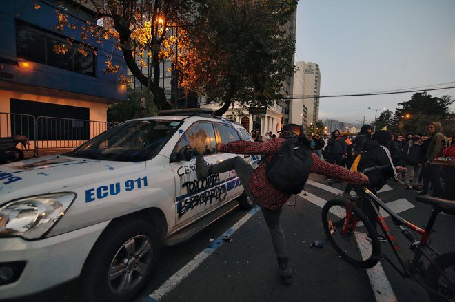 V središču Quita univerzitetni študentje uničujejo policijsko vozilo med demonstracijami proti vladi predsednika Guillerma Lassa v okviru protestov pod vodstvom avtohtonih prebivalcev. Ekvadorska policija je napovedala aretacijo visokega domorodnega voditelja Leonidasa Iza, ki je vodil protestno gibanje po vsej državi proti visokim cenam goriva.&nbsp;Foto Cristina Vega Rhor Afp
