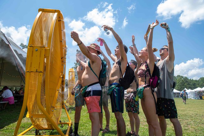 Obiskovalci Bonnaroo Music and Arts festivala, ki se te dni odvija v v Manchestru v Tennesseeju, stojijo pred velikanskim ventilatorjem, da bi se ohladili na vroč poletni dan. Foto: Valerie Macon/Afp
