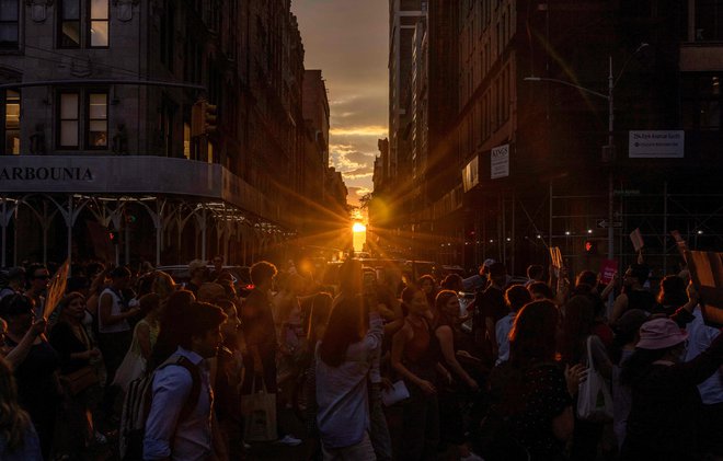 Sončni zahod za newyorškim trgom&nbsp;Washington Square Park, kjer so se zbrali demonstranti proti končanju ameriške zvezne pravice do splava. Foto Alex Kent/Afp
