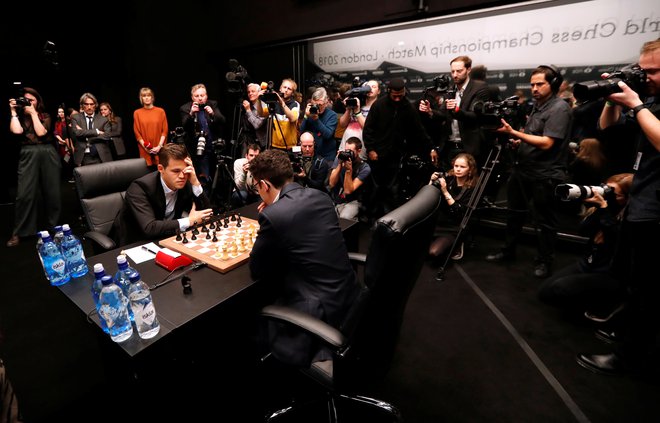 Magnus Carlsen in Fabiano Caruana med prvo partijo&nbsp;v Londonu leta 2018. FOTO: Paul Childs/Reuters
