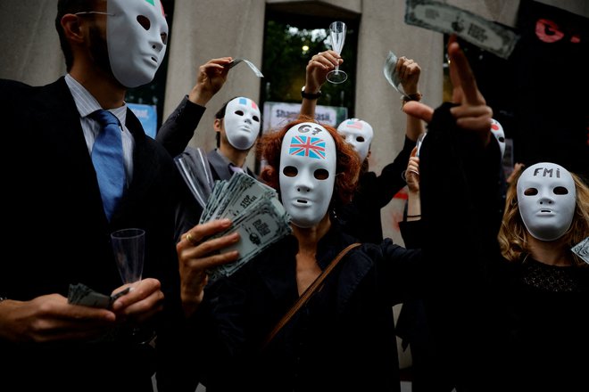 Aktivisti se udeležujejo akcije &raquo;Dolg za podnebje&laquo;, s katero od skupine G7 zahtevajo odpis dolga za države globalnega juga pred sedežem Mednarodnega denarnega sklada v Parizu. Foto: Sarah Meyssonnier/Reuters
