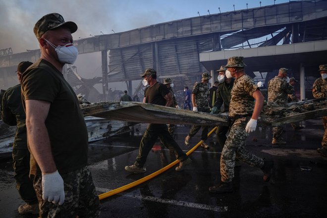 Reševalci in vojaki med odstranjevanjem posledic ruskega napada na nakupovalno središče v ukrajinskem Kremenčuku. FOTO: Reuters
