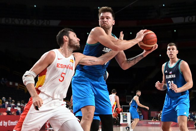 Luka Dončić v dvoboju z&nbsp;Rodolfom&nbsp;&raquo;Rudyjem&laquo; Fernandezom na tekmi skupinskega dela olimpijskega turnirja v Tokiu.&nbsp;FOTO: Aris Messinis/AFP
