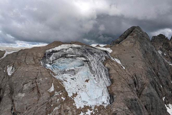 Na grozljive podnebne razmere je javnost najglasneje opomnila nesreča na Marmoladi, kjer se je z ledenika utrgal serak in pod seboj pokopal doslej neznano število ljudi. Foto Tiziana Fabi/AFP
