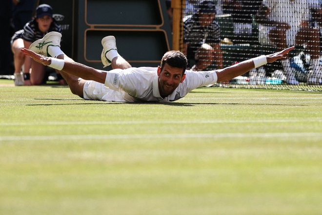 Novak Đoković se je v Wimbledonu veselilil 21. lovorike za veliki slam in ima le eno manj od Rafaela Nadala, ki bi ga lahko ujel na OP ZDA, če bo lahko igral na zadnjem največjem turnirju sezone. FOTO: Adrian Dennis/AFP
