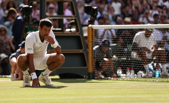 Novak Đoković je obljubil več stvari v primeru zmage v Wimbledonu. Travo je že poskusil, zdaj bo moral kupiti tudi kilogram sladoleda. FOTO: Adrian Dennis/AFP
