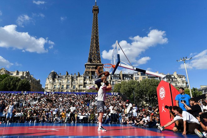 Tyler Currie je s pomočjo Luke Dončića takole zabil v senci Eifflovega stolpa. FOTO: Julien De Rosa/AFP
