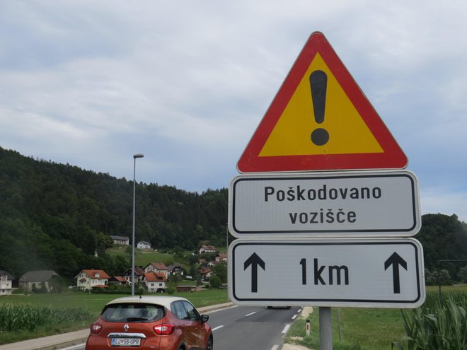 Tri leta že stoji znak, ki voznike opozarja na poškodovano cestišče. FOTO:&nbsp;Bojan Rajšek/Delo

