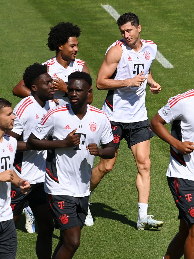 Robert Lewandowski na treningu Bayerna v pogovoru z nemškim reprezentantom Sergeom Gnabryjem. FOTO: Christof Stache/AFP
