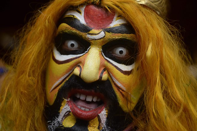 Hindujski vernik, oblečen v Potharajuja, brata hindujske boginje Mahakali, nastopa med procesijo festivala Bonalu v templju Sri Ujjaini Mahakali v indijskem mestu Secunderabad. Foto: Noah Seelam/Afp
