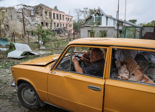 Jevgen Habač pred svojo hišo v Kramatorsku, ki je bila uničena v ruskem napadu. FOTO: Gleb Garanič/Reuters
