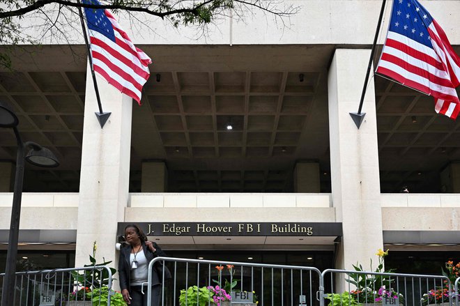 Oseba hodi med varnostno ograjo pred sedežem FBI v Washingtonu. FOTO: Mandel Ngan/AFP
