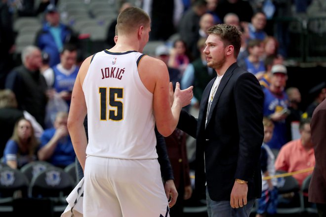 Nikola Jokić v pogovoru z Luko Dončićem po tekmi lige NBA v Dallasu.&nbsp;FOTO: Tom Pennington/AFP
