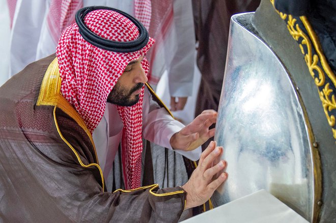 Prestolonaslednik in dejanski vladar Saudske Arabije je vsaj uradno veren mož, na fotografiji umiva črni kamen, muslimansko relikvijo v osrednji mošeji najsvetejšega muslimanskega mesta Meke. FOTO: AFP
