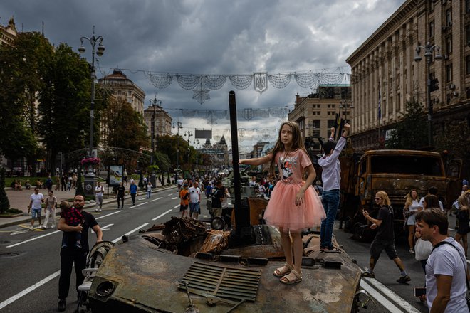 Dekle stoji na uničenem ruskem vojaškem tanku na ulici Khreshchatyk v Kijevu, ki so jo pred ukrajinskim dnevom neodvisnosti, ki ga bodo praznovali 24. avgusta, spremenili v vojaški muzej na prostem. Foto: Dimitar Dilkoff/Afp

