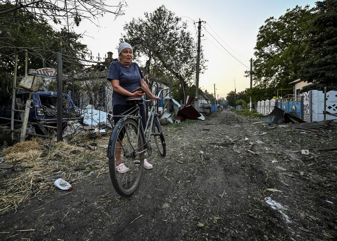 Ženska stoji blizu stanovanjskih hiš, uničenih zaradi ruskega vojaškega napada v Čaplinu. FOTO: Reuters
