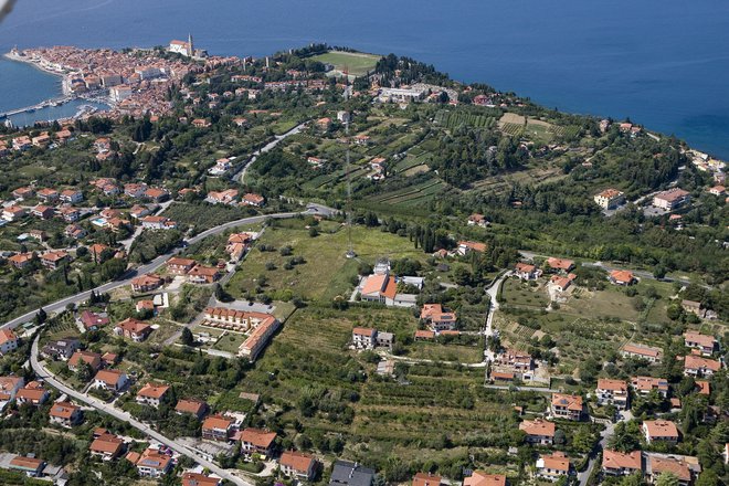 Parcela, kjer bodo zrasle Sončne vile, so tik ob zemljišču RTV oddajnka Beli Križ, nedaleč od antene, sredi fotografije. Foto Jaka Jeraša
