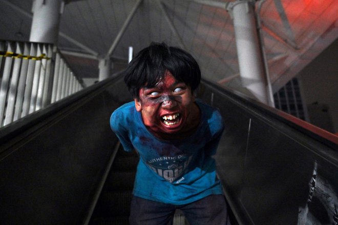 Moški pozira kot zombi na postaji podzemne železnice v okviru dogodka Vlak za apokalipso, ki je del pobude za spodbujanje potnikov k uporabi hitrega mestnega prometa v Džakarti. Mesto je znano po svojem pošastnem prometu, zato je upravljavec hitrega potniškega prometa v Džakarti vlak in postajo spremenil v prizorišče krvave apokalipse zombijev - in na predstavo povabil prave potnike. Foto: Adek Berry/Afp
