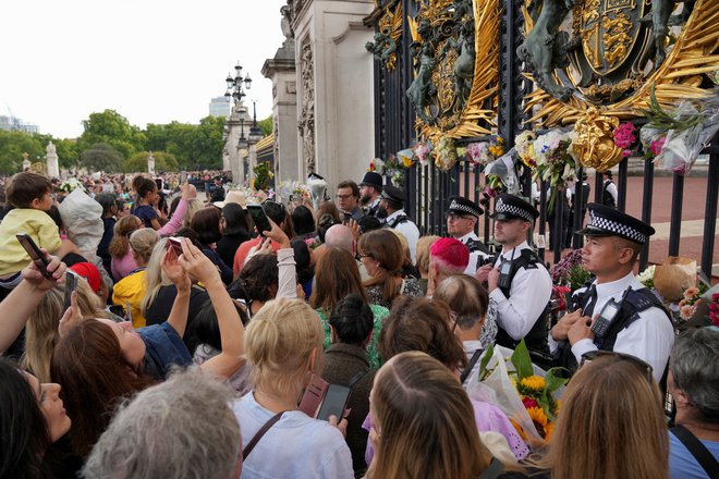 Takoj po smrti kraljice so se pred Buckinghamsko palačo v Londonu začeli zbirati ljudje, včeraj pa so pozdravili novega kralja Karla III. Foto Maja Smiejkowska/Reuters
