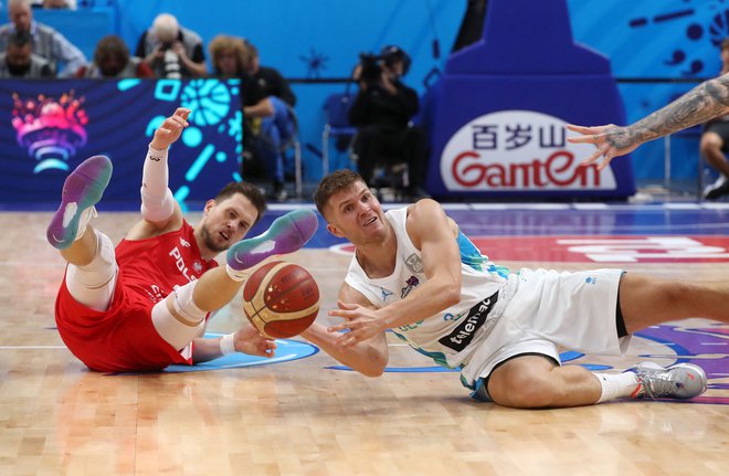 Poljski junak četrtfinalne zmage proti zdaj že bivšim evropskim prvakom Slovencem Mateusz Ponitka (levo) se je boril kot lev in igral kot LeBron James. FOTO: Oliver Behrendt/AFP
