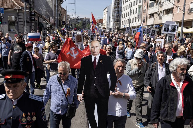 Zoran Marič, predsednik srbske ruske manjšinske stranke, s podobo ruskega predsednika Vladimirja Putina med letošnjim pohodom v spomin na 77. obletnico zmage nad nacistično Nemčijo. Foto Marko Djurica/Reuters
