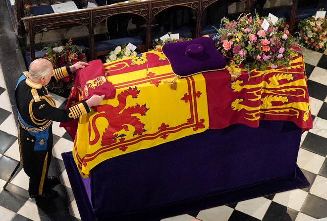 Kralj Karel III. je položil kraljičin prapor gardnih brigadirjev, ki naj bi ga pred pokopom dali h kraljici. FOTO: Jonathan Brady/Pool via Reuters
