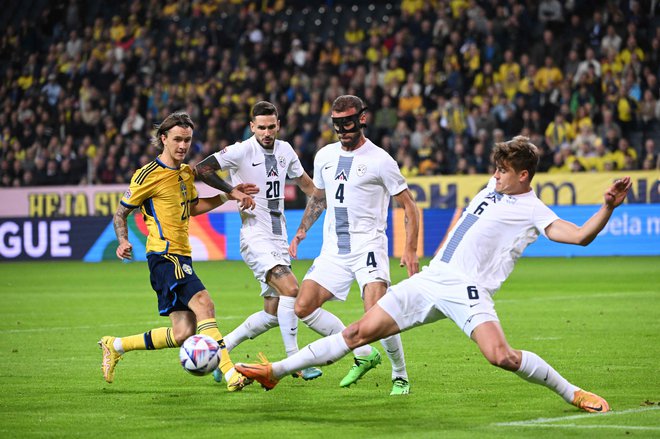 Tudi švedski adut Kristoffer Olsson je občutil, kako deluje, ko se nate spravijo trije zagrizeni slovenski branilci. FOTO: Jonathan Nackstrand/AFP
