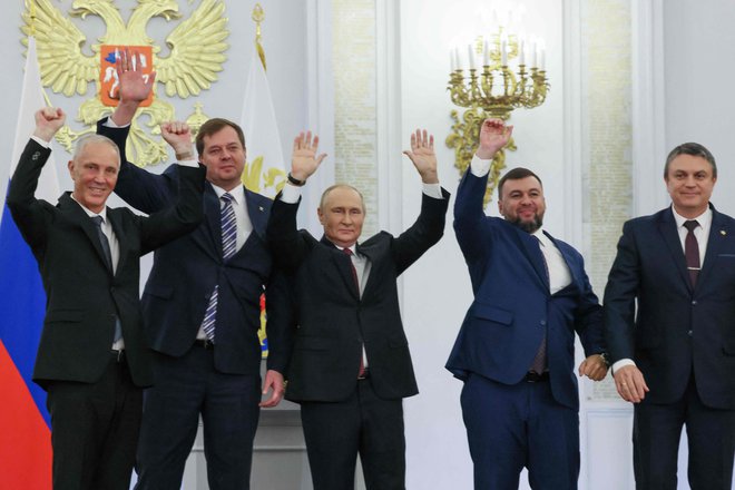 Ruski predsednik Vladimir Putin (v sredini) je s proruskimi voditelji štirih ukrajinskih regij, kjer so pred dnevi potekali sporni referendumi, podpisal sporazum o njihovi priključitvi k Ruski federaciji. FOTO:&nbsp;Mihail Mecel/AFP
