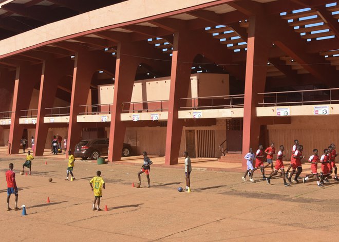 Trening nogometašev pred nacionalnim štadionom&nbsp;v&nbsp;Conakryju, ki je bil leta 2009 prizorišče krvavega pokola. Za smrt več kot 150 protestnikov so v zadnjih septembrskih dneh letošnjega leta začeli soditi 11 moškim.&nbsp;FOTO: Cellou Binani/AFP
