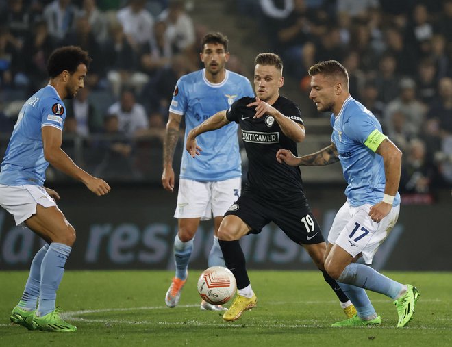 Tomi Horvat (v črnem) je bil takole okrožen s tremi nogometaši Lazia, nemočen je bil tudi odlični napadalec Ciro Immobile. FOTO: Erwin Scheriau/AFP
