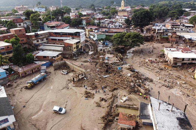 V Venezueli se je zaradi močnih padavin in posledične poplave reke v soboto ponoči sprožil zemeljski plaz, v katerem je umrlo najmanj 25 ljudi, več kot 50 pa je pogrešanih. Predsednik Nicolás Maduro je po državi razglasil tridnevno žalovanje. Zemeljski plaz se je sprožil v mestu Las Tejerias, ki je od glavnega mesta Caracas oddaljeno približno 50 kilometrov. Mesto je zdaj prekrito z blatom in ruševinami, prav tako je tam prekinjena preskrba z elektriko. FOTO: Yuri Cortez/AFP
