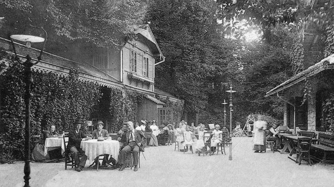 Gostinski vrt ob koncu 19. stoletja med lesenim gostiščem Kazinskega društva iz leta 1835 (levo) in Švicarijo iz leta 1852 (desno). Foto Arhiv Muzeja novejše zgodovine Slovenije.
