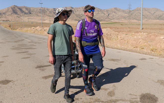 Santiago Sanchez se je na pot podal z vozičkom, na katerem vleče kovček s šotorom, tabletami za dezinfekcijo vode in kuhalnikom. Fotografija je nastala v iraškem Kurdistanu.&nbsp;FOTO: Charlotte Bruneau/Reuters
