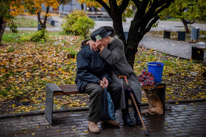 Starejši par se objema in tolaži na klopci v frontnem mestu Bakhmut v regiji Doneck na vzhodu Ukrajine. Mesto znano po rudnikih soli in vinogradih, že več mesecev napadajo ruske sile, ki so večinoma v defenzivi v drugih regijah po Ukrajini. Foto: Dimitar Dilkoff/Afp
