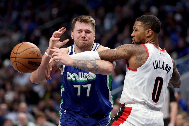 Luko Dončića (na fotografiji ga ovira Damian Lillard) so poskušali ustaviti na vse mogoče načine. FOTO: Tom Pennington/AFP
