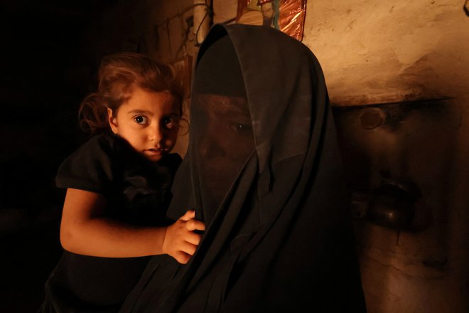 48-letna Hikma Meteab in njena triletna hčerka Ghufran živita v družinski hiši v iraški vasi Al-Bu Hussain, ki je locirana ob bregu izsušenega kanala. Hikmin mož Abbas Elwan je avgusta storil samomor, potem ko so bili poskusi iskanja vode za njegova izsušena kmetijska zemljišča neuspešni. Abbas je prejemal mesečno nadomestilo za brezposelnost, vendar se je zaradi zmanjševanja pridelka in naraščajočih cen hrane zadolžil. V obupu je poskušal kopati vodnjake, da bi gojil zelenjavo. Vsak vodnjak je stal toliko kot njegovo mesečno nadomestilo. Vsakič se je voda pojavila za nekaj dni, nato pa presahnila. &raquo;To je bilo njegovo zadnje upanje, a vode ni bilo,&laquo; je za Reuters povedal Abbasov brat Ali. Foto: Alaa Al-Marjani/Reuters

