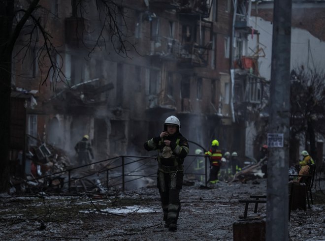 Reševalci&nbsp;na prizorišču ruskega raketnega napada na stanovanjsko naselje v mestu Vižgorod blizu Kijeva. FOTO:&nbsp;Gleb Garanich/Reuters
