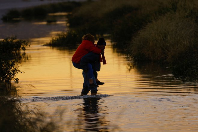 Migranti, ki iščejo azil, iz Ciudad Juareza v Mehiki prečkajo reko Rio Bravo, da bi se predali agentom ameriške mejne patrulje in zaprosili za azil v mestu El Paso v Teksasu. Foto: Jose Luis Gonzalez/Reuters

