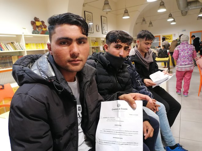 Mladenič iz Pakistana kaže papir, da v Trstu čaka že več kot mesec dni na prosto mesto v sprejemnem centru. FOTO: Nataša Čepar/Delo
