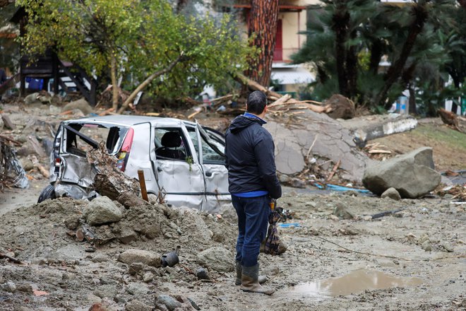 Velika količina blata, vode in naplavin je&nbsp;zajela več deset objekov ter odnašala avtomobile.&nbsp;FOTO: Ciro De Luca/Reuters
