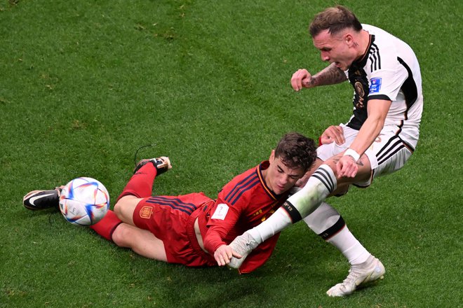 Španski vezni igralec Gavi je dobil udarec v glavo od nemškega branilca Davida Rauma med nogometno tekmo skupine E svetovnega prvenstva v Katarju 2022 med Španijo in Nemčijo. Foto: Kirill Kudryavtsev/Afp
