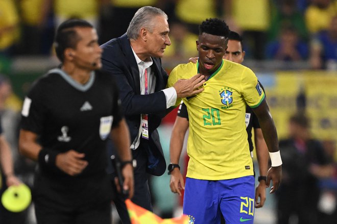 Tudi Vinicius Junior prisluhne, ko spregovori selektor Tite. FOTO: Fabrice Coffrini/AFP
